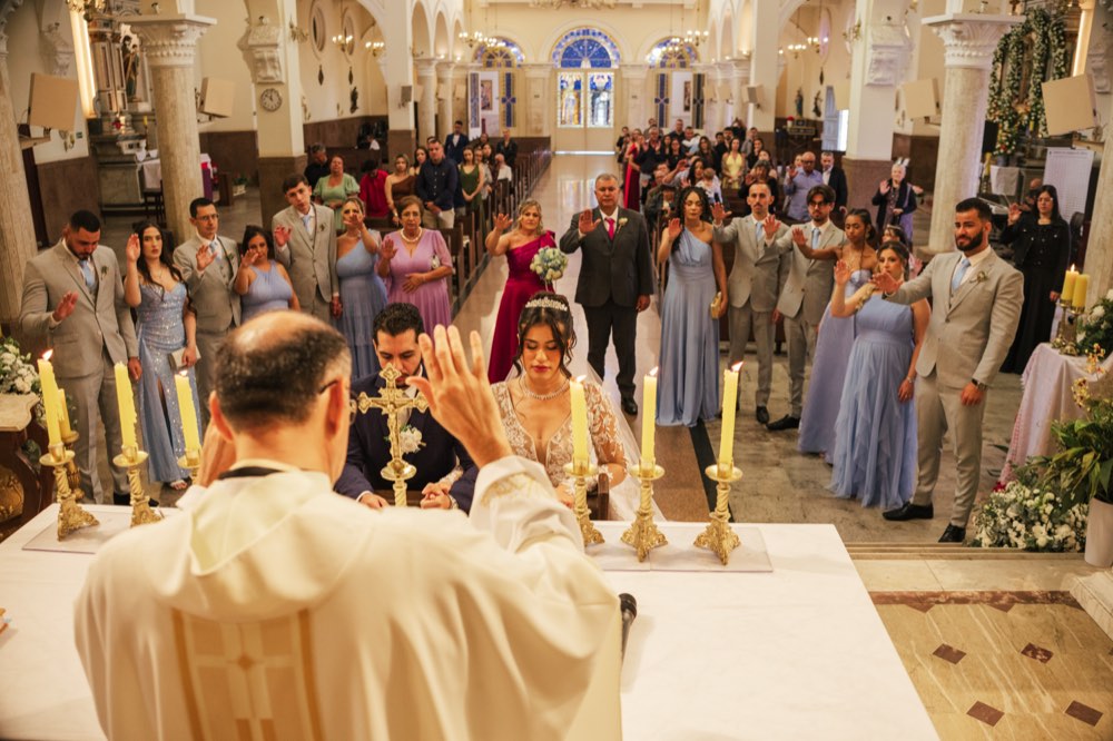 Padre abençoando os noivos diante dos padrinhos
